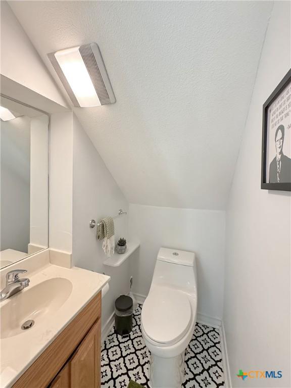 149 Gallagher Dr, Canyon Lake, TX 78133 - bathroom featuring vaulted ceiling, vanity, and a textured ceiling