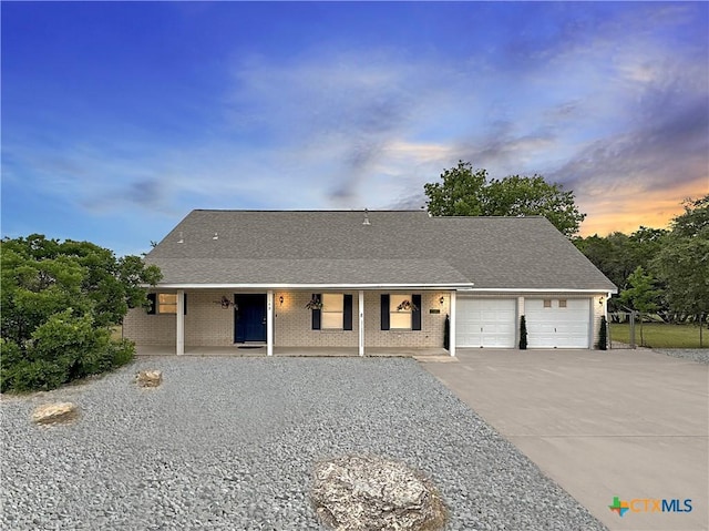 149 Gallagher Dr, Canyon Lake, TX 78133 - view of front facade with a porch, driveway, an attached garage, and brick siding
