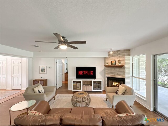 149 Gallagher Dr, Canyon Lake, TX 78133 - living area with a ceiling fan, a brick fireplace, and wood finished floors
