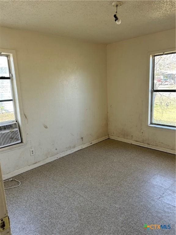 empty room with cooling unit and a textured ceiling