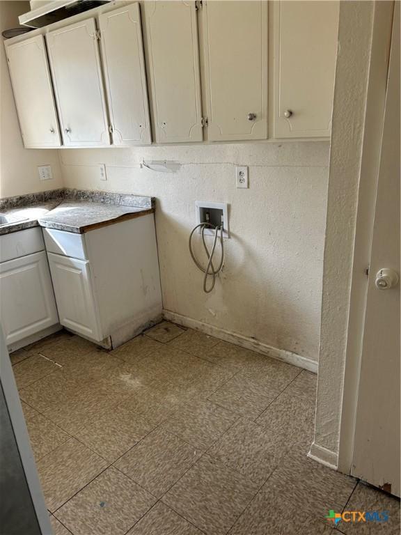 washroom with cabinets and hookup for a washing machine