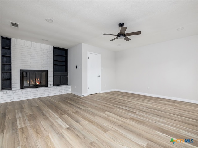 unfurnished living room featuring ceiling fan, baseboards, wood finished floors, and a fireplace