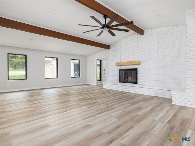 unfurnished living room with ceiling fan, wood finished floors, a fireplace, and plenty of natural light