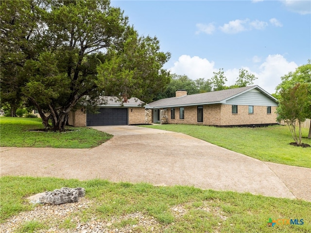 single story home with concrete driveway, a front lawn, and a chimney