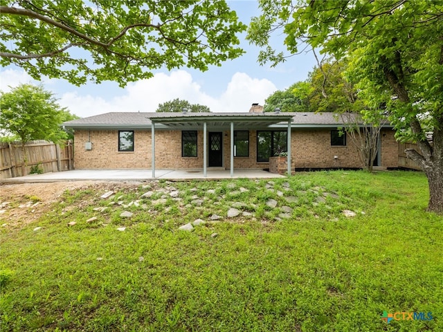 back of property featuring a patio area, brick siding, and a chimney