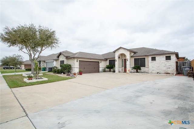 view of front of house with concrete driveway, an attached garage, stone siding, and a front lawn