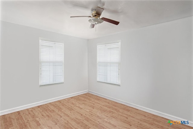 spare room with wood finished floors, baseboards, and ceiling fan