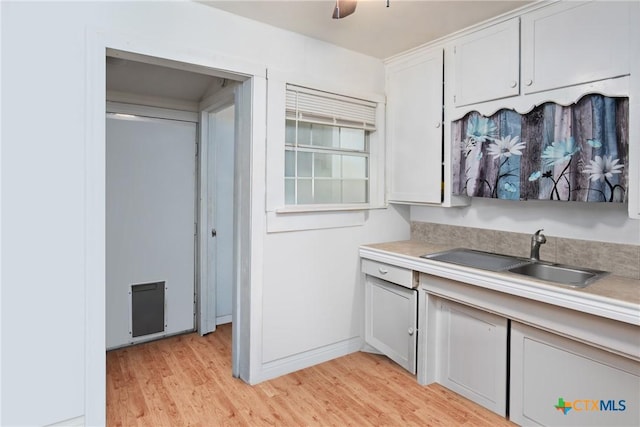 kitchen with a ceiling fan, light countertops, light wood-style floors, and a sink