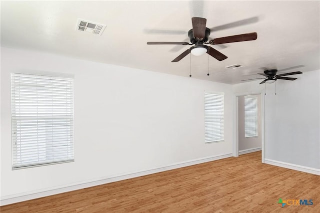 empty room with visible vents, baseboards, and light wood-style flooring