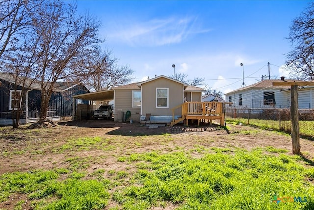 back of house featuring a carport, a deck, driveway, and fence