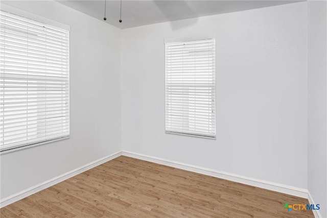 empty room with baseboards and wood finished floors