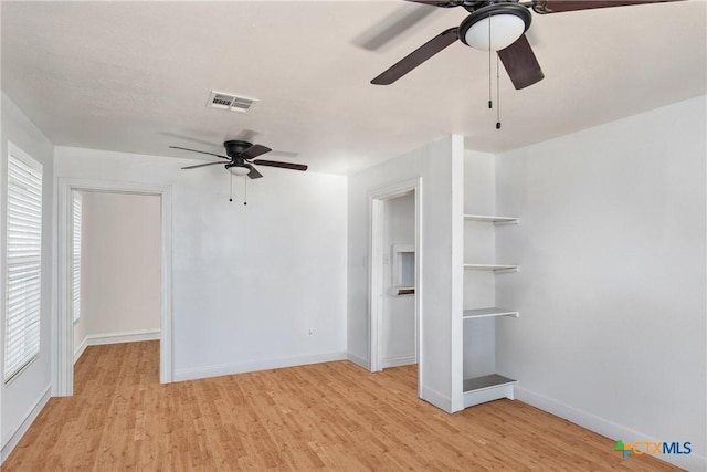 interior space featuring visible vents, baseboards, light wood-style floors, and a ceiling fan