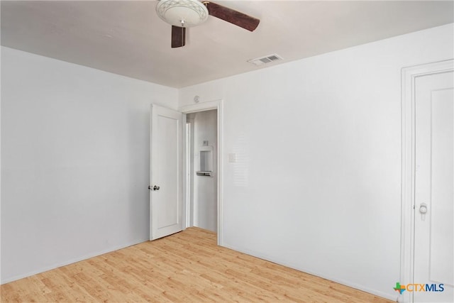 spare room with light wood-style floors, visible vents, and ceiling fan