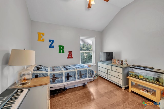 bedroom with ceiling fan, light hardwood / wood-style floors, and vaulted ceiling