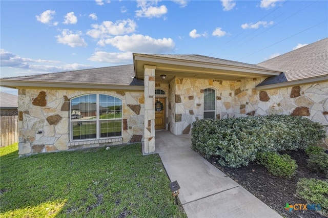 10103 Taylor Renee Dr, Killeen, TX 76542 - view of exterior entry with stone siding, a yard, and a shingled roof