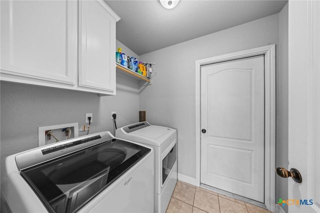 10103 Taylor Renee Dr, Killeen, TX 76542 - washroom with washing machine and clothes dryer, cabinet space, light tile patterned floors, and a textured ceiling