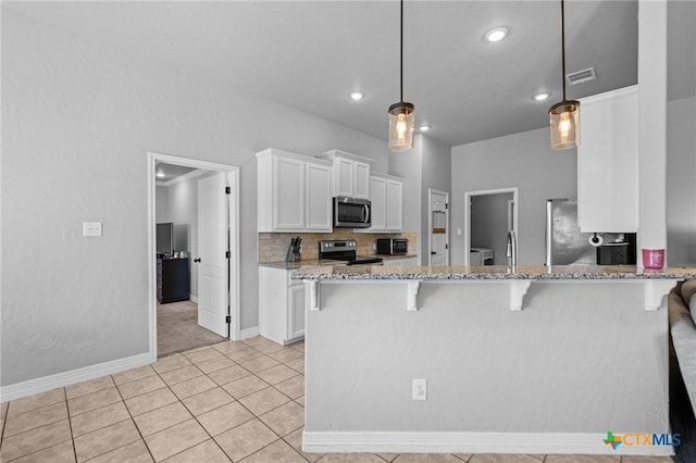 10103 Taylor Renee Dr, Killeen, TX 76542 - kitchen with stainless steel appliances, light stone countertops, white cabinets, a breakfast bar, and light tile patterned floors