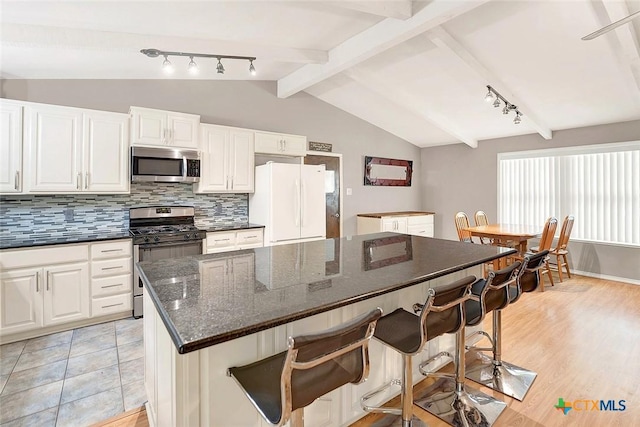 1802 Chestnut St, Floresville, TX 78114 - kitchen featuring stainless steel appliances, rail lighting, a breakfast bar, and decorative backsplash