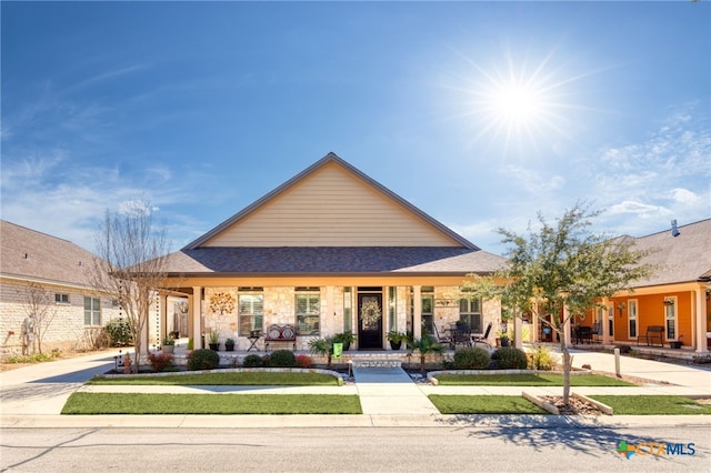 view of front of property featuring a shingled roof and a porch