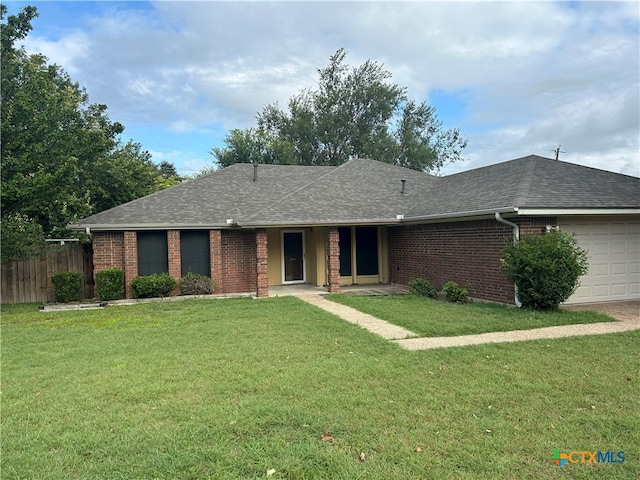 ranch-style home featuring a garage and a front lawn