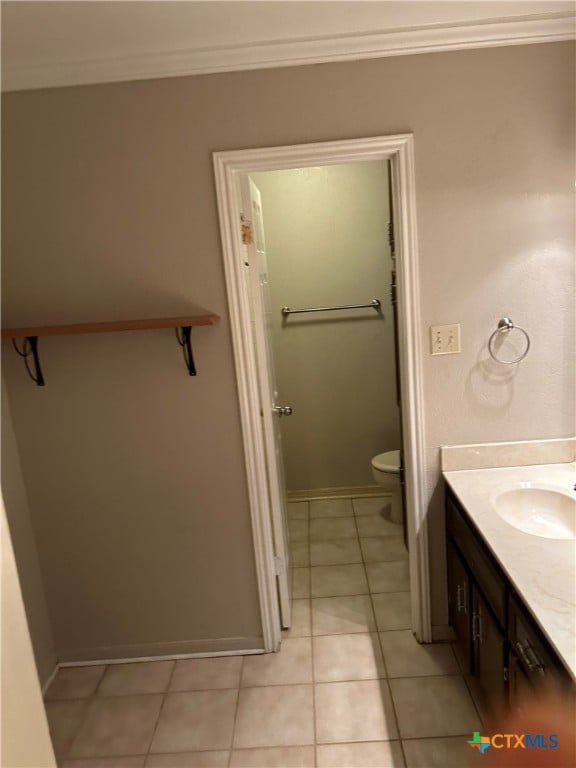 bathroom featuring toilet, vanity, tile patterned floors, and crown molding