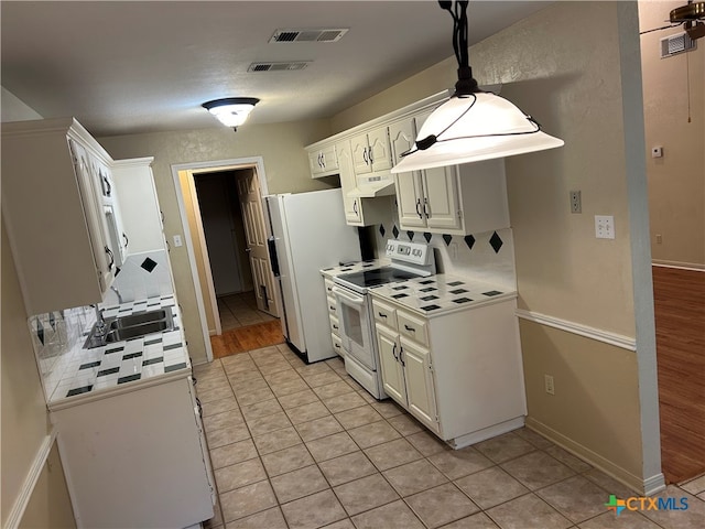 kitchen with white cabinetry, sink, white appliances, light hardwood / wood-style flooring, and decorative backsplash