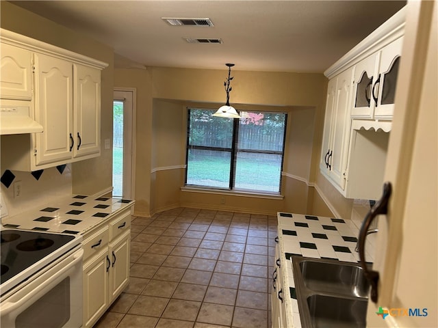 kitchen with white range with electric cooktop, pendant lighting, extractor fan, light tile patterned flooring, and white cabinetry