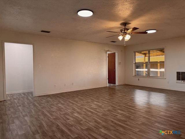 548 County Road 303, Shiner, TX 77984 - spare room featuring dark wood finished floors, ceiling fan, a textured ceiling, and heating unit