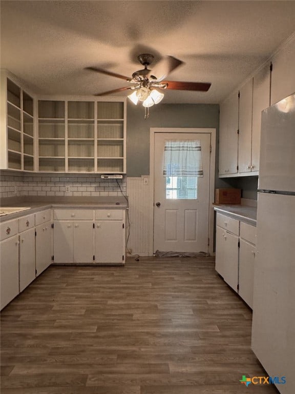 548 County Road 303, Shiner, TX 77984 - kitchen with freestanding refrigerator, open shelves, white cabinetry, dark wood-type flooring, and a ceiling fan