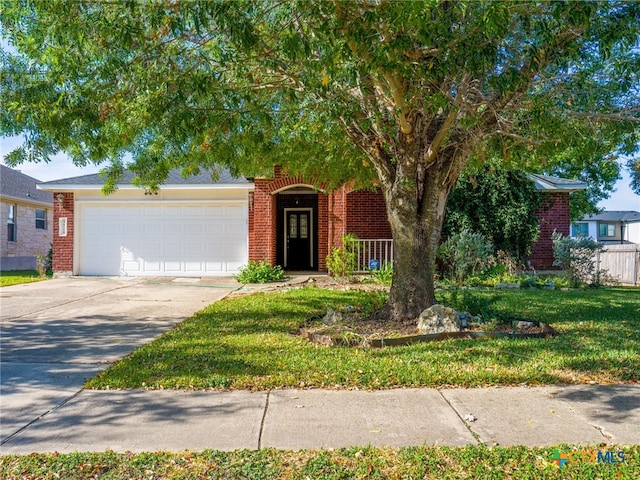 obstructed view of property with a garage and a front lawn