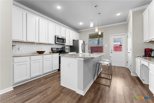 7628 Copper Creek Trl, Temple, TX 76502 - kitchen with stainless steel appliances, ornamental molding, dark wood finished floors, tasteful backsplash, and a center island with sink