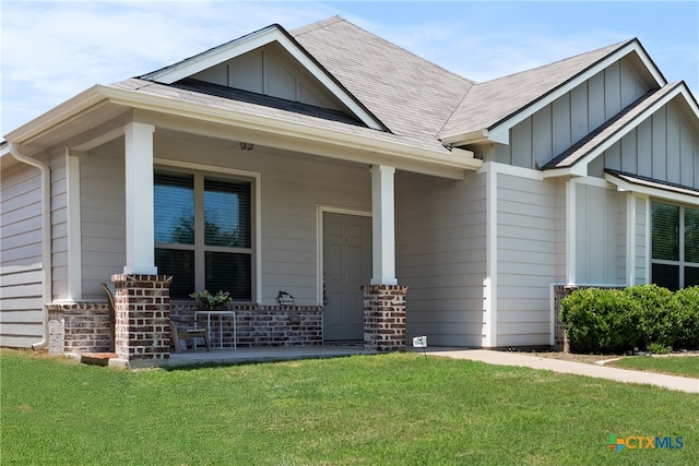 7628 Copper Creek Trl, Temple, TX 76502 - view of front of property with board and batten siding, a porch, a front lawn, and roof with shingles