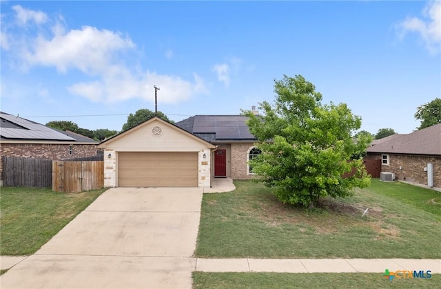 single story home with fence, solar panels, and a front yard