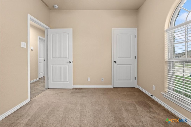 unfurnished bedroom with carpet and baseboards