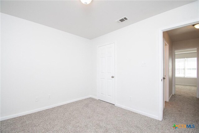 unfurnished bedroom featuring carpet floors, baseboards, and visible vents