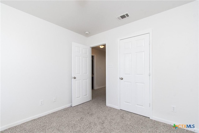 unfurnished bedroom with baseboards, visible vents, and light colored carpet