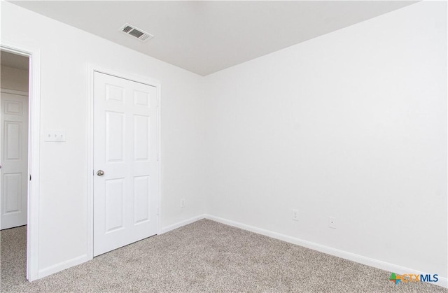 unfurnished bedroom featuring carpet floors, visible vents, and baseboards