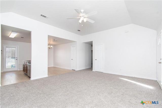 empty room featuring light carpet, visible vents, vaulted ceiling, and ceiling fan with notable chandelier