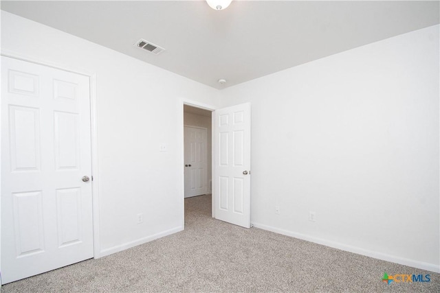 unfurnished bedroom with carpet flooring, visible vents, and baseboards