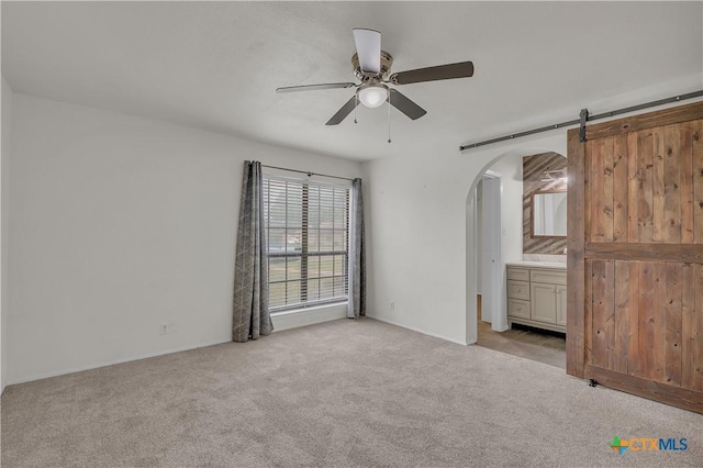 2002 Buckskin Trl, Temple, TX 76502 - unfurnished bedroom featuring arched walkways, light carpet, connected bathroom, and baseboards