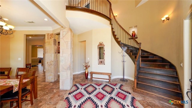 staircase with an inviting chandelier and crown molding