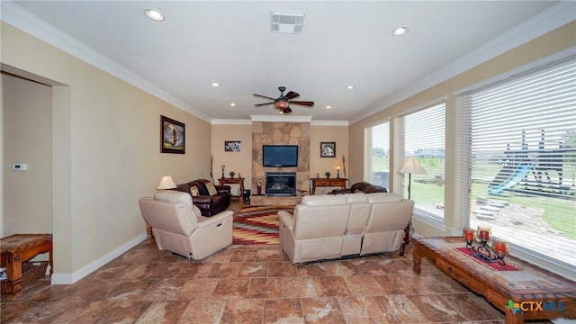 living room with a stone fireplace, ceiling fan, and ornamental molding