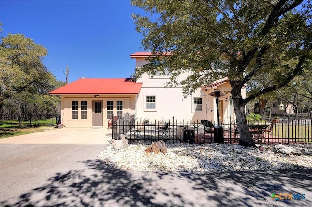 view of front facade with stucco siding, a patio area, and fence