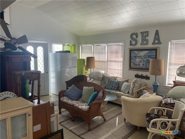 tiled living room with a healthy amount of sunlight and vaulted ceiling