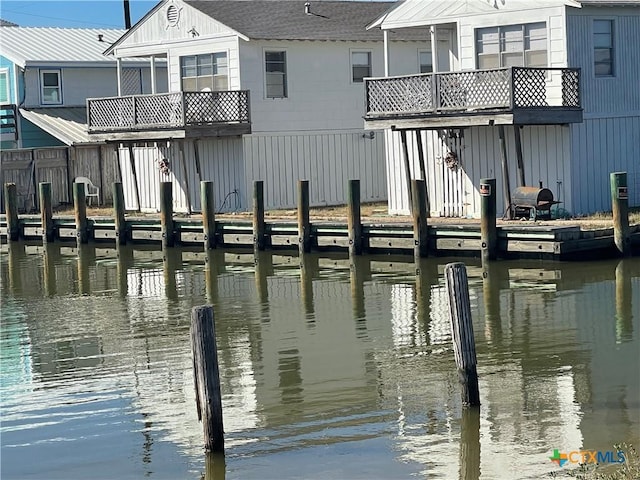 view of dock featuring a water view and a balcony