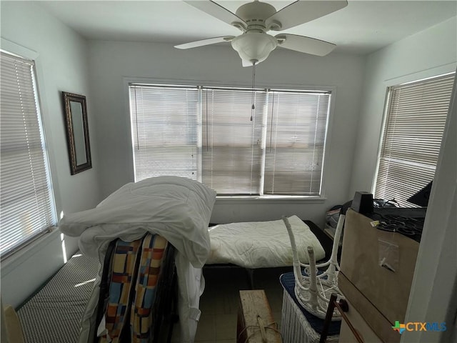 tiled bedroom featuring ceiling fan