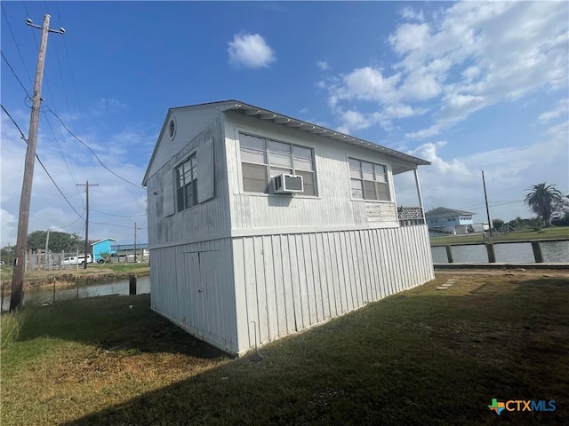 view of side of property with cooling unit, a yard, and a water view