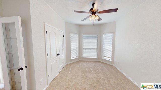 unfurnished room featuring light carpet and ceiling fan