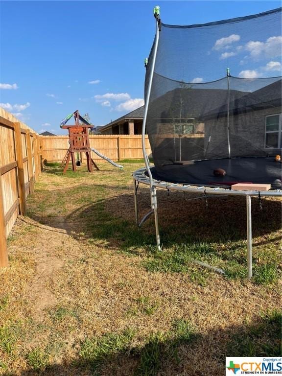 view of yard featuring a playground and a trampoline