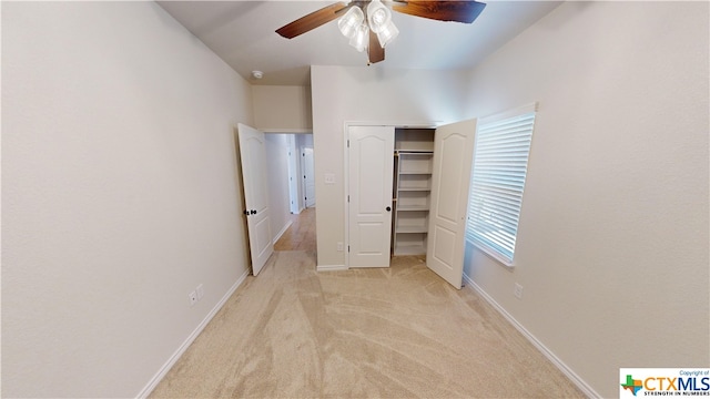 unfurnished bedroom with ceiling fan, light carpet, and a closet